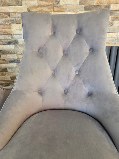 Gray tufted dining chair against a stone wall